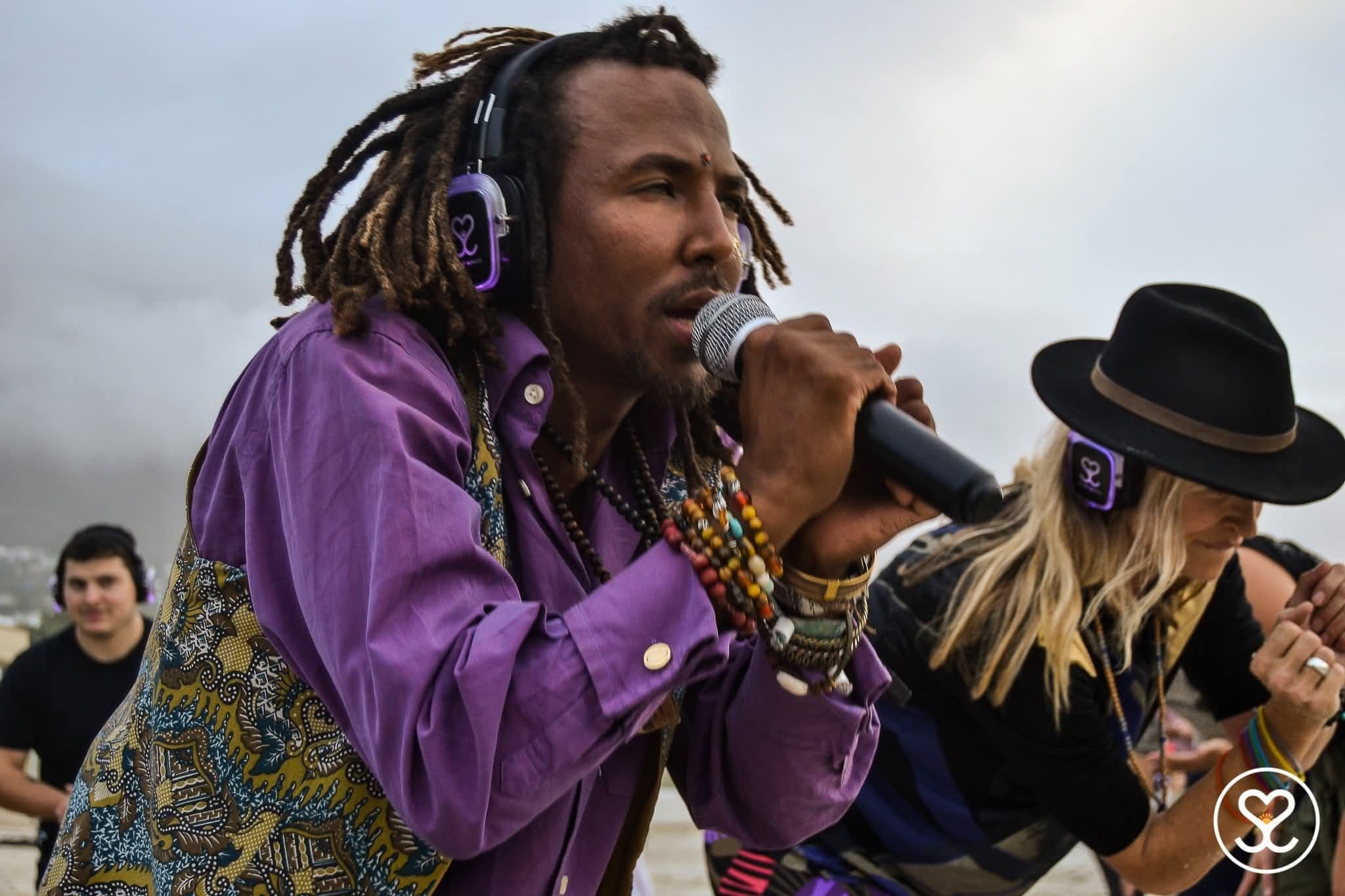 Julian at a festival singing into a mic